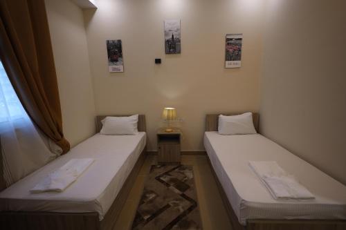 2 łóżka pojedyncze w pokoju z oknem w obiekcie فندق حياة دمنهور - Hayat Hotel Damnhour w mieście Damanhûr
