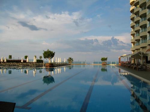 a large swimming pool next to a building at Goldcity Otel Kargıcak in Alanya