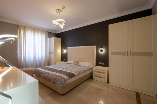 a bedroom with a bed and a black wall at Goldcity Otel Kargıcak in Alanya