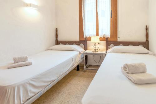 2 Betten in einem Zimmer mit einem Tisch und einer Lampe in der Unterkunft Sant Carles 23 - apartamento con vistas al mar in Girona