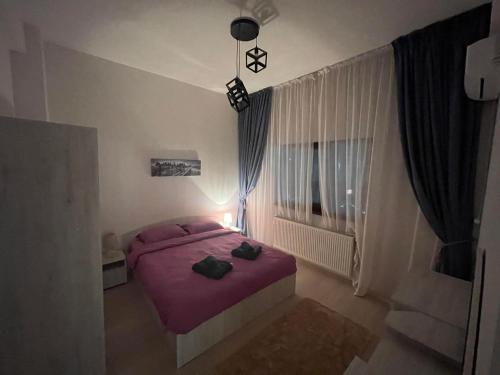 um quarto com uma cama roxa com dois sacos em Divine Apartments River Towers em Iaşi