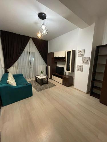 uma sala de estar com um sofá verde e uma televisão em Divine Apartments River Towers em Iaşi