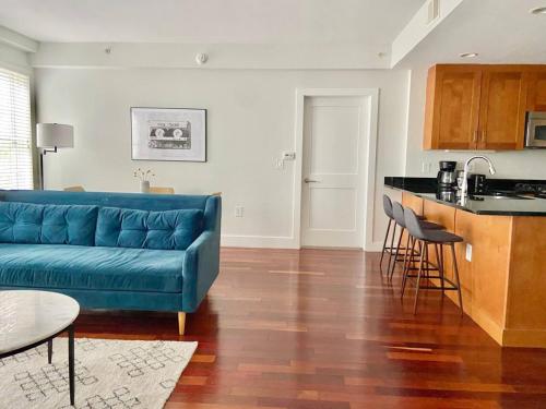sala de estar con sofá azul y cocina en 440-Luxury Apt Near Light Rail, en Hoboken