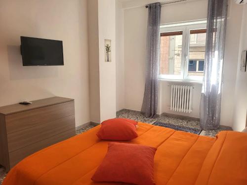 una camera con letto arancione e TV di Garibaldi Square Central City a Bari