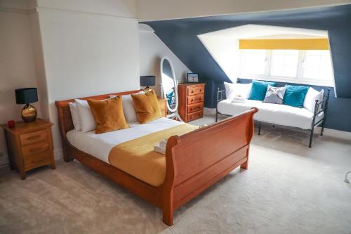 a bedroom with a large bed and a couch at Stylishly decorated 3 bed home close to the sea on the Wirral Peninsula in Hoylake