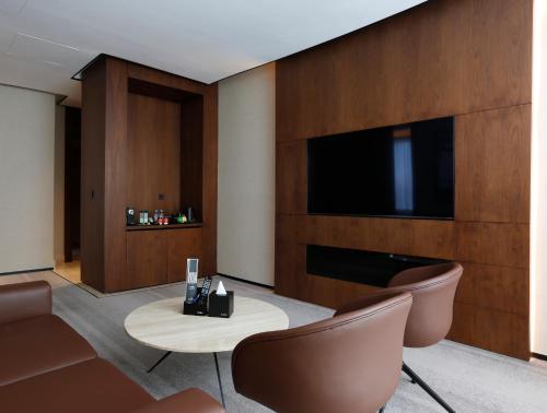 a hotel room with a tv and a table and chairs at ALMA Hotel Riyadh in Riyadh