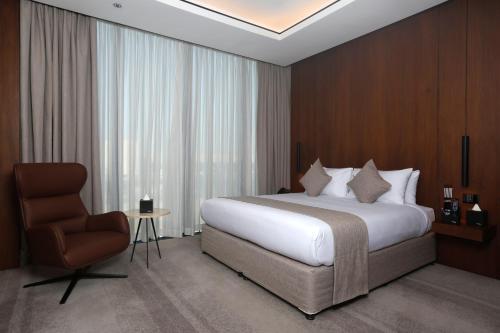 a hotel room with a bed and a chair at ALMA Hotel Riyadh in Riyadh