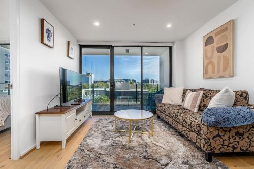 a living room with a couch and a tv at North-Facing APT 3 min to Canberra Times Fountain - Hosted by CanStay in Canberra