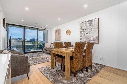 a living room with a wooden table and chairs at North-Facing APT 3 min to Canberra Times Fountain - Hosted by CanStay in Canberra