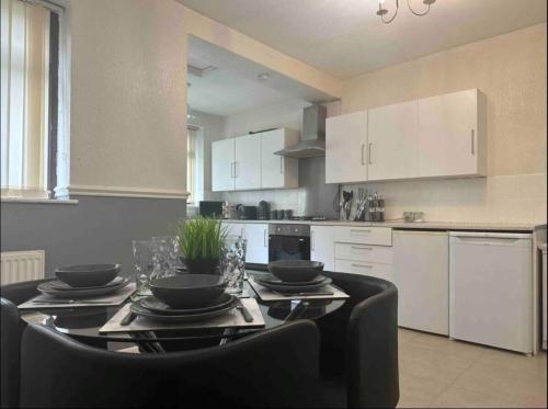 uma cozinha com uma mesa com pratos e tigelas em Charming 2-BR Property - Sleeps 5 em Warrington