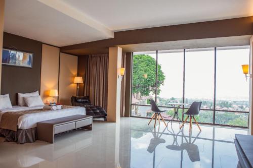 a bedroom with a bed and a large window at Dago Highland Resort in Bandung