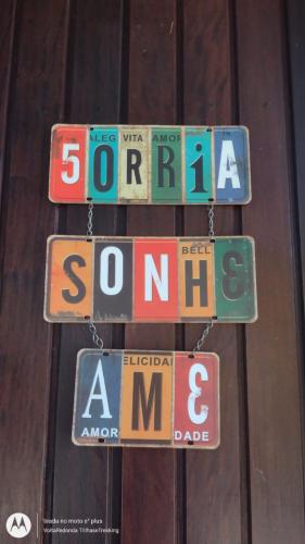 a group of signs hanging from a wooden wall at Pousada dos Girassóis in Conservatória