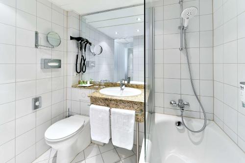 a bathroom with a toilet and a sink and a shower at NH Erlangen in Erlangen
