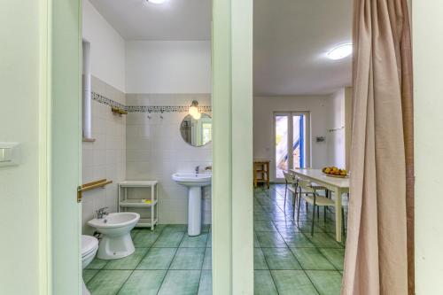 een badkamer met een toilet, een wastafel en een spiegel bij Il Carrubo Martella in Gagliano del Capo