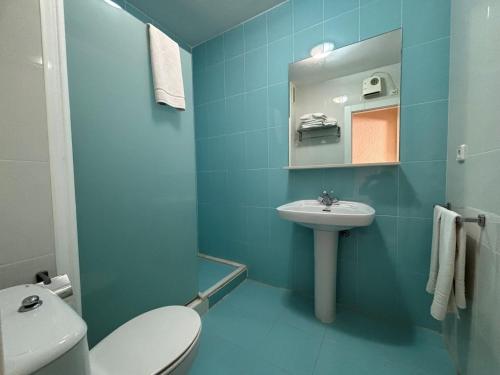 une salle de bain bleue avec des toilettes et un lavabo dans l'établissement Retiro Park II - Serviden, à Dénia