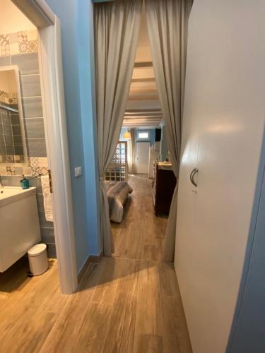 a hallway leading into a room with a sink and a bathroom at Stalingrado Home - Fiera Bologna in Bologna