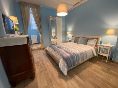 a blue bedroom with a bed and a mirror at Stalingrado Home - Fiera Bologna in Bologna