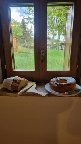 ein Tisch mit einem Fenster und ein Kuchen auf einem Teller in der Unterkunft La Casa di LucaPietro Dimora Storica in Spoleto