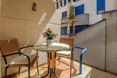 einen Tisch und Stühle auf einem Balkon mit einer Blumenvase in der Unterkunft Casa El Nieto 3BR Sea View in Puerto de las Nieves