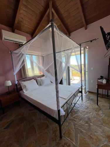 a bed with a canopy in a room at Alseides Villas in Chortáta