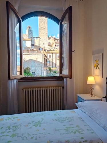 a bedroom with a bed and a window with a view at Affittacamere Chiti Melania in San Gimignano