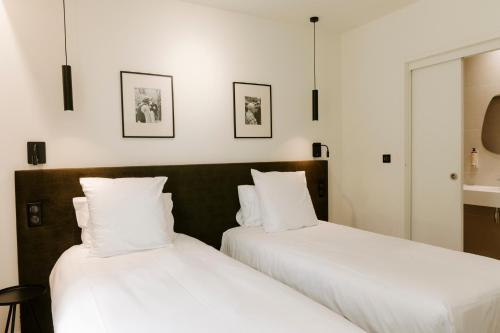 two beds sitting next to each other in a room at Soko Hotels-Pont du Gard in Remoulins