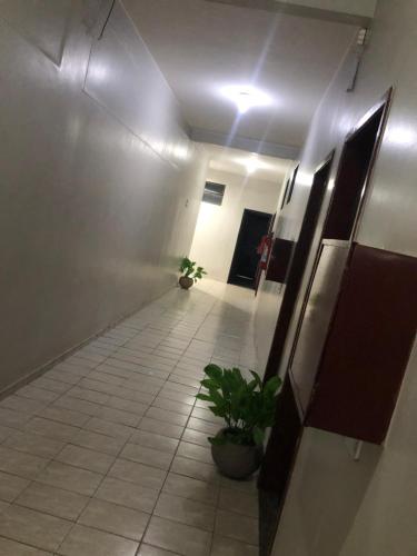 a hallway with a potted plant in a building at Hotel Canal Hum Pistão in Brasilia