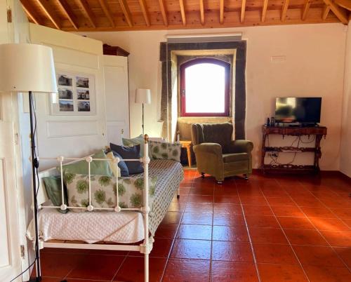 a living room with a couch and a chair at Casa do Facho in Praia da Vitória
