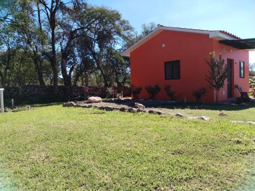 a house with a yard next to a red house at Armonia - La Victoria - Tarija in Tarija