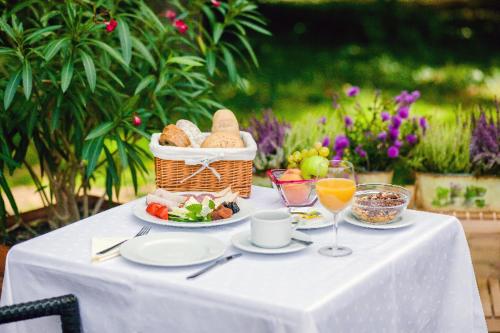 einen Tisch mit einem Korb Brot und einem Teller Essen in der Unterkunft Főnix Medical Wellness Resort in Csitár