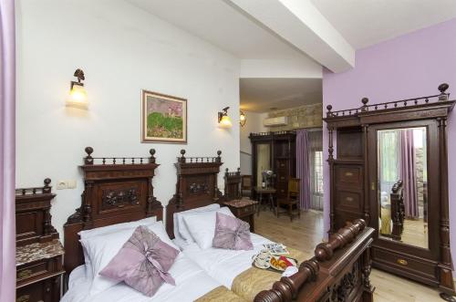 a bedroom with a bed with white sheets and purple pillows at Palace Derossi II in Trogir