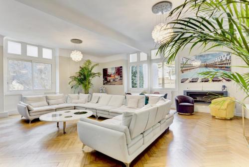 Elle comprend un salon doté d'un mobilier blanc et d'un lustre. dans l'établissement Le Palais Beausite - Palais à Cannes, à Cannes