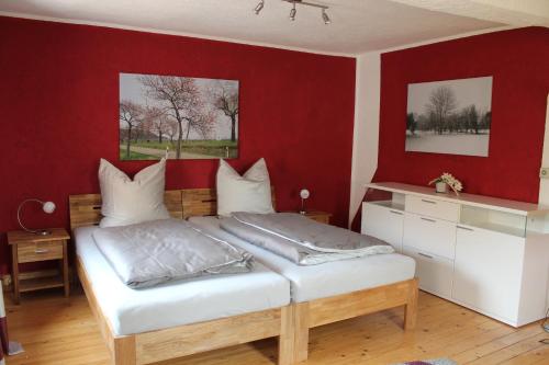 ein Schlafzimmer mit einem Bett mit einer roten Wand in der Unterkunft Ferienhaus Wingarda in Weingarten