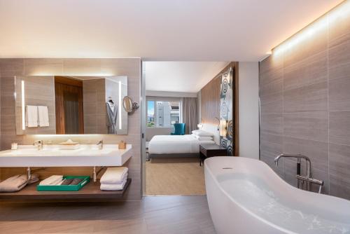 a bathroom with a tub and a bedroom with a bed at Hyatt Centric San Isidro Lima in Lima