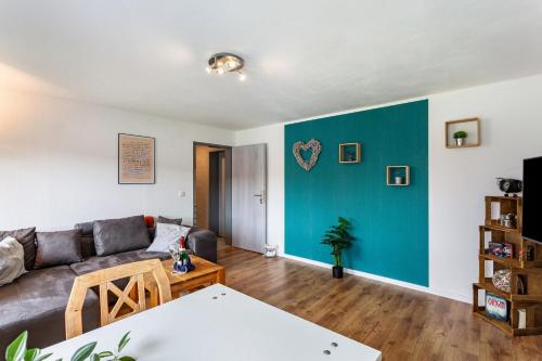 ein Wohnzimmer mit einem Sofa und einer blauen Wand in der Unterkunft Ferienwohnung Wilde Schanze in Hoppecke
