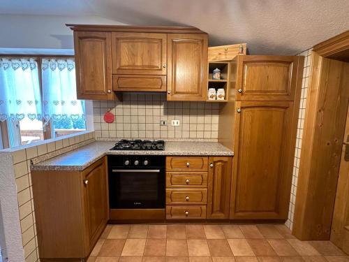 a kitchen with wooden cabinets and a stove top oven at Appartamenti Detomaso in Masarei