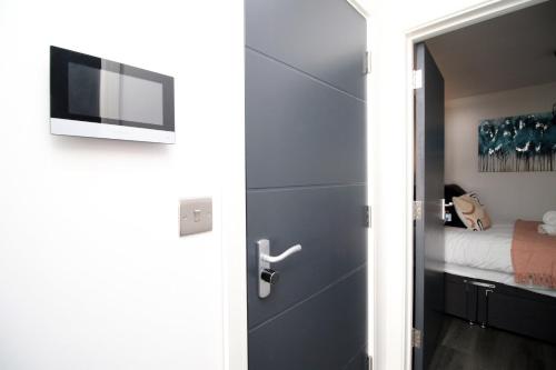 Una puerta que conduce a un dormitorio con cama en Boutique one bedroom apartment in Cardiff, en Cardiff
