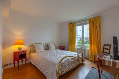 1 dormitorio con 1 cama, TV y ventana en Chez Maryse et Guy - Bel Appt pour 4 avec jardin, en La Ville-aux-Clercs