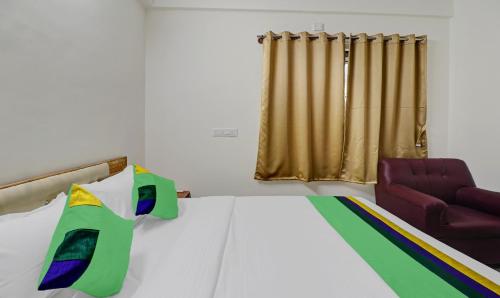 a bedroom with a bed and a chair at Treebo SLN Heritage in Bengaluru