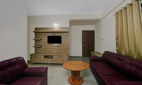 a living room with a couch and a table at Treebo SLN Heritage in Bengaluru
