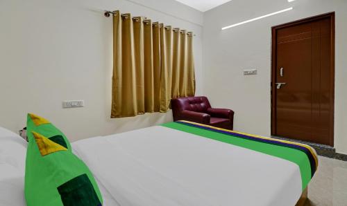 a bedroom with a bed and a leather chair at Treebo SLN Heritage in Bengaluru