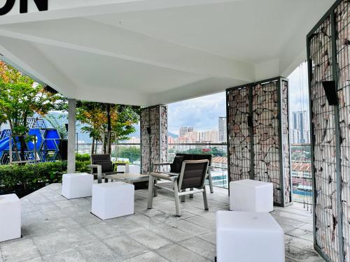 a patio with chairs and tables on a building at Apartment in Georgetown 3BR-10pax in Jelutong