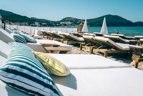 a row of lounge chairs and tables on a beach at Appartement avec terrasse à 100m de la plage in Saint-Cyr-sur-Mer