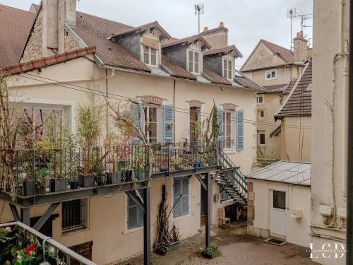 een appartementencomplex met potplanten op de balkons bij Le Berbisey Dijon Centre in Dijon