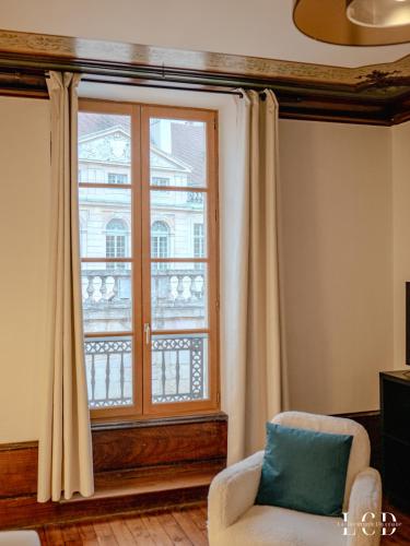 - un salon avec une fenêtre et une chaise dans l'établissement Le Berbisey Dijon Centre, à Dijon