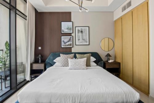 - une chambre avec un grand lit blanc dans l'établissement GuestReady - Contemporary studio in Business Bay, à Dubaï