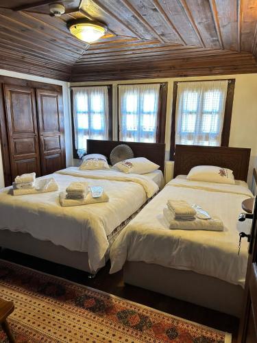 2 camas en una habitación con techos y ventanas de madera en SEMRA HANIM KONAĞI en Safranbolu