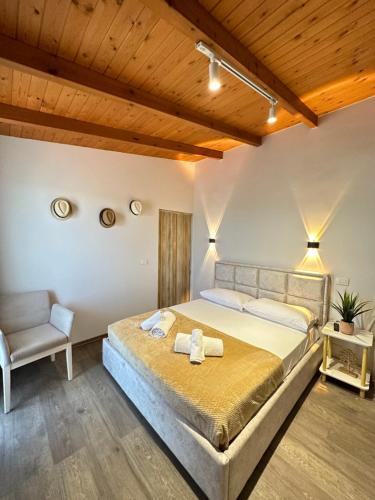 - une chambre avec un grand lit et une chaise dans l'établissement Anel Suites, à Vlorë