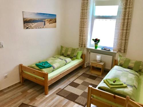 ein Schlafzimmer mit einem Bett, einem Sofa und einem Fenster in der Unterkunft Abelia Ferienwohnung GröF in Helmstedt