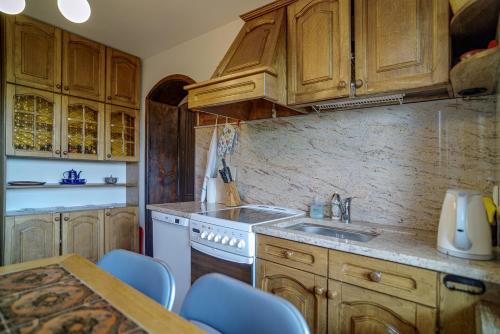 a kitchen with wooden cabinets and a sink and a table at Apartament Kaszubski in Ostrzyce